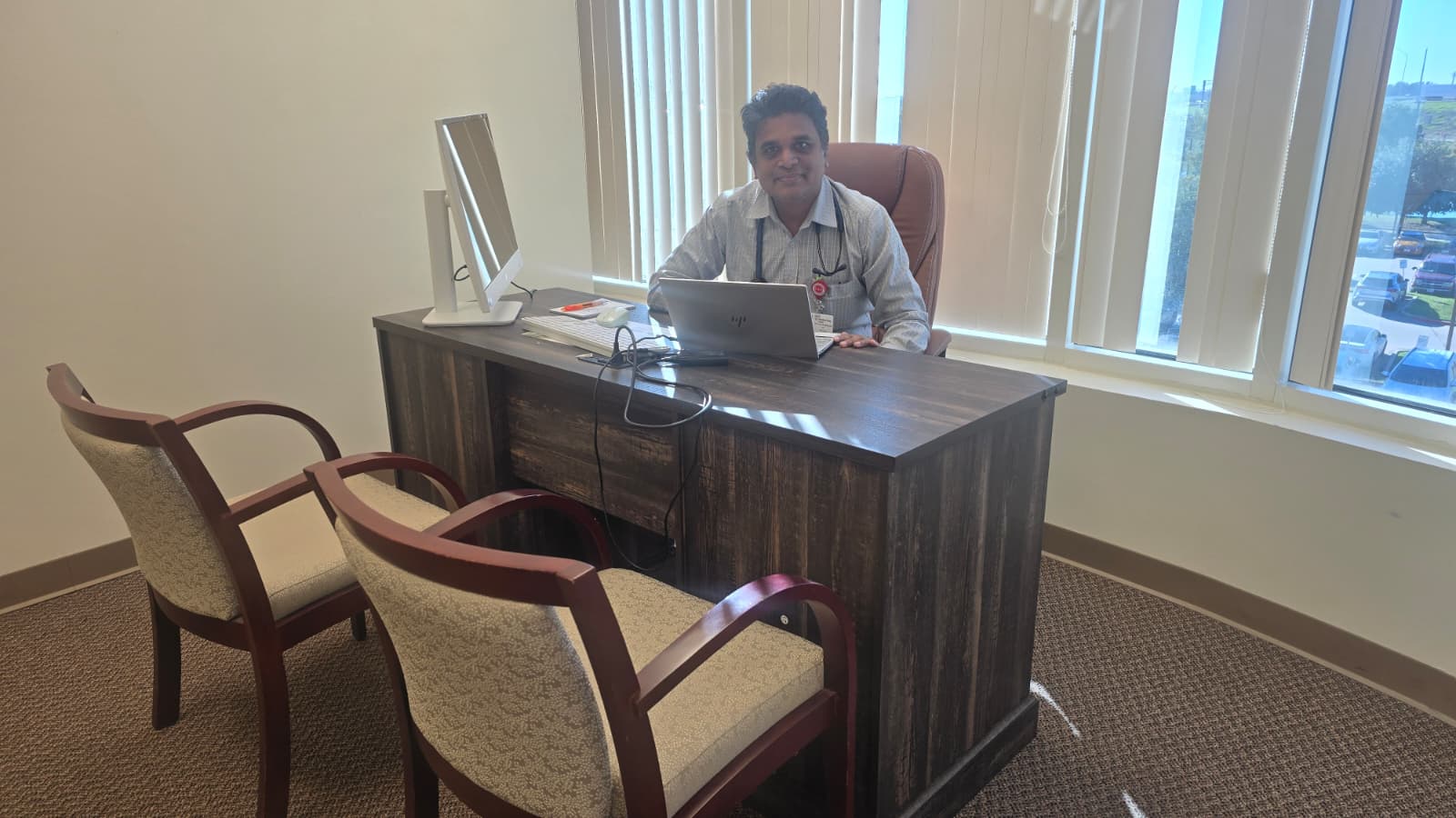 Dr. Devasahayam at his desk in the consultation office